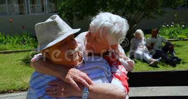 积极的高加索老夫妇在养老院花园拥抱对方的正面景色